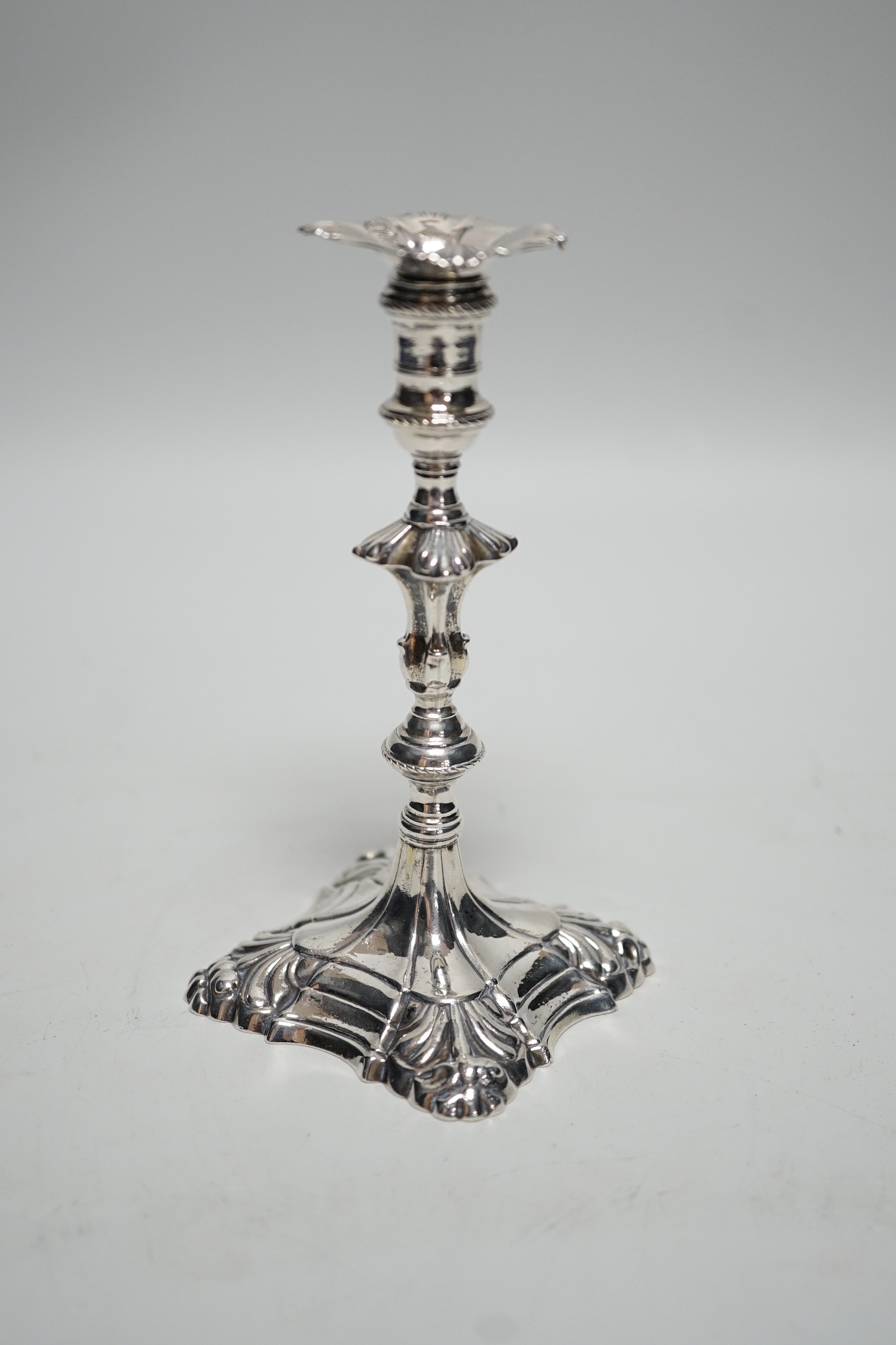A George III cast silver taper stick, with turned knopped stem and engraved crest, maker, JH, London, 1764, 13.3cm, 4.7oz